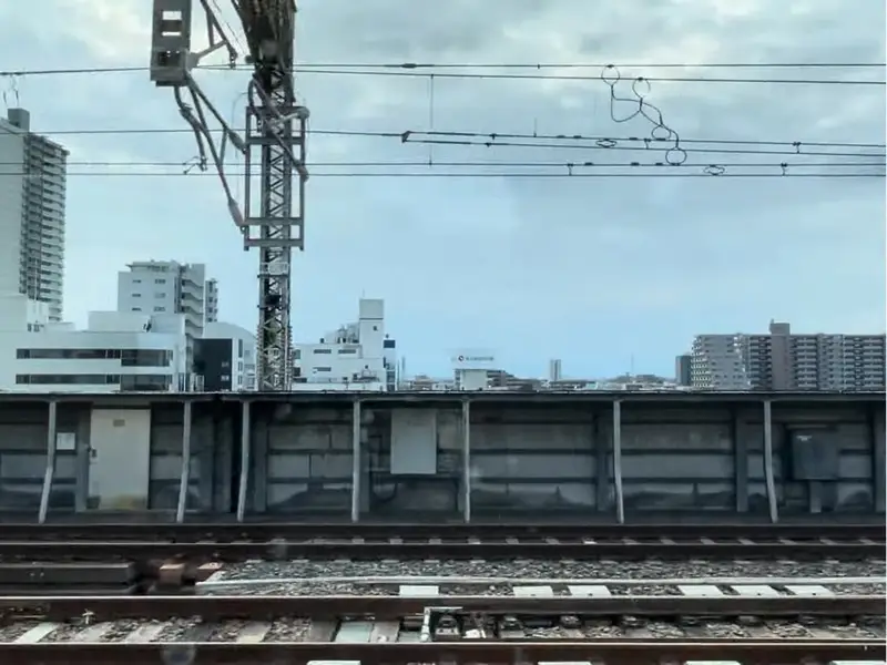 奥に市街地の建物が見える鉄道風景